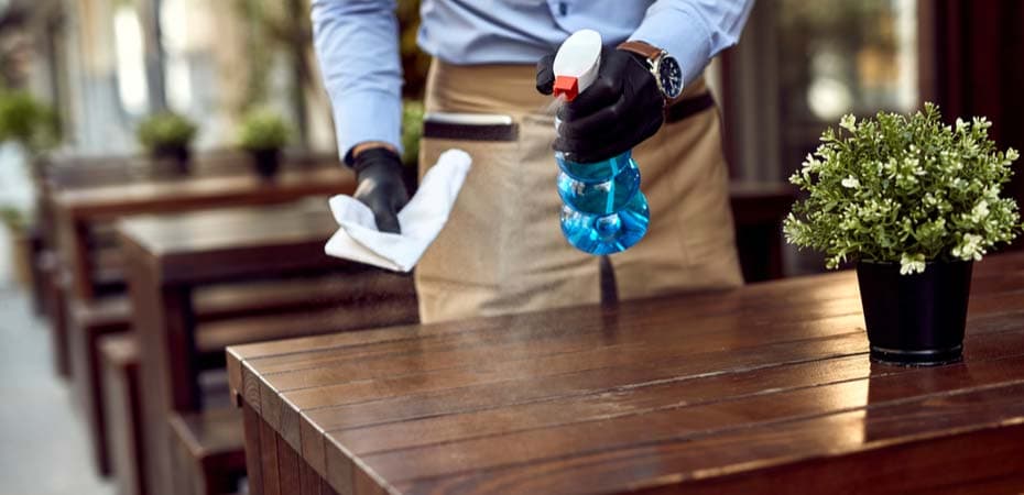 Someone cleaning table with disinfectant