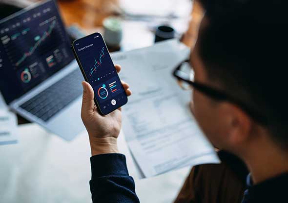 Man looking at financials on mobile phone