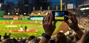 Person filling a baseball game with their phone in the stadium